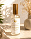 Room spray bottle labeled 'Joha Collections' on a surface with decorative elements.
