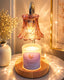 Decorative candle with a glass shade on a wooden base, surrounded by soft lighting.