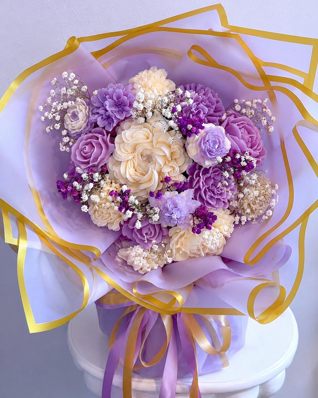 Bouquet of purple and white flowers with decorative ribbons on a white background Main image