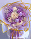 Bouquet of purple and white flowers with decorative ribbons on a white background