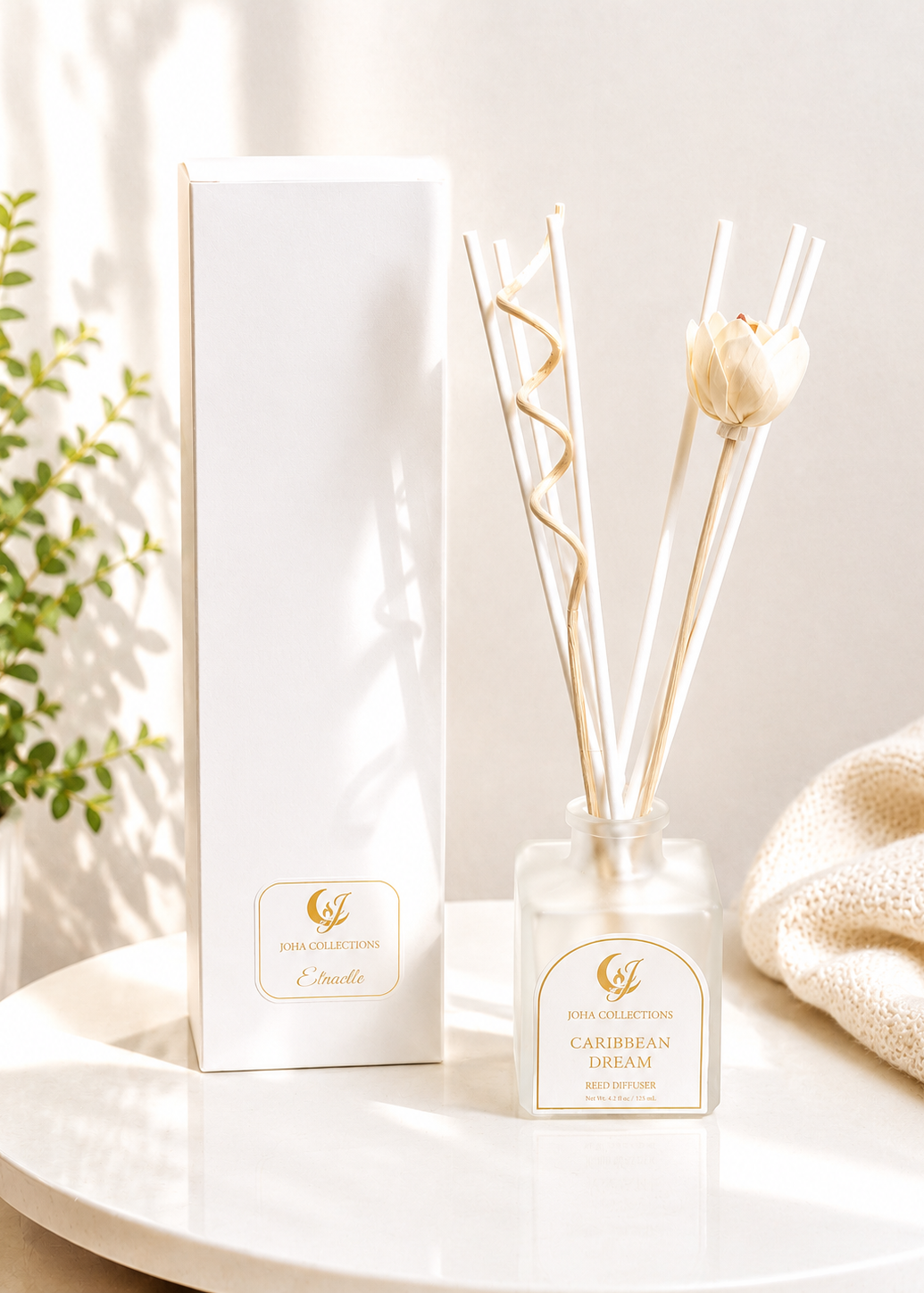 Diffuser with decorative sticks and packaging on a white surface