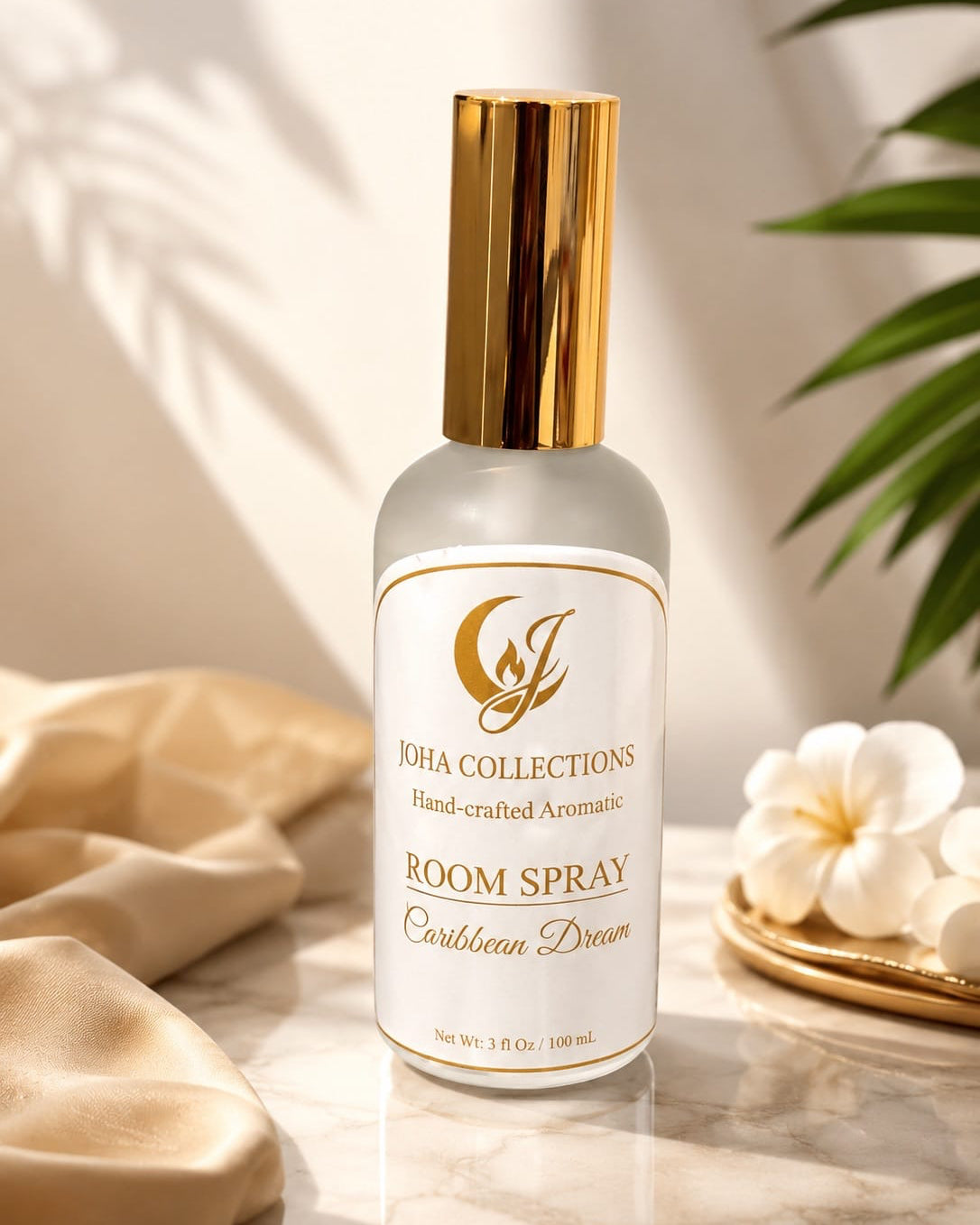 Room spray bottle with gold cap on a marble surface with decorative elements