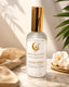 Room spray bottle with gold cap on a marble surface with decorative elements