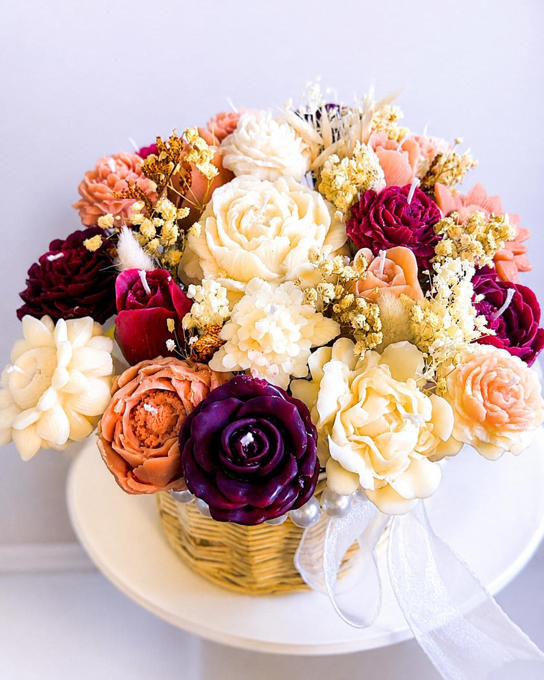 Colorful flower arrangement in a basket on a white background Main image