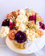 Colorful flower arrangement in a basket on a white background
