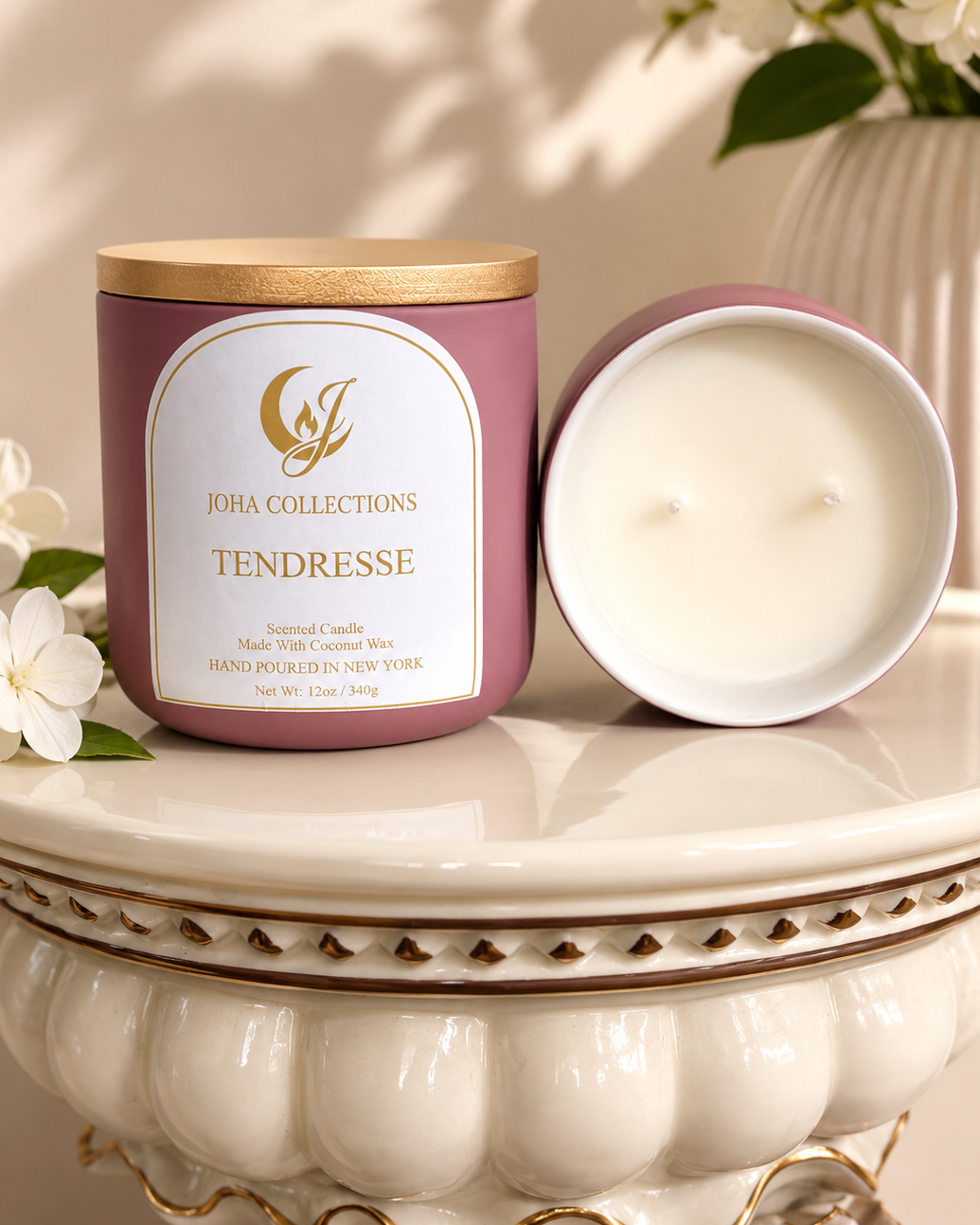 Joha Collections Tendresse candle on a decorative stand with flowers in the background