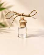 Clear glass diffuser with wooden beads and a string on a neutral background