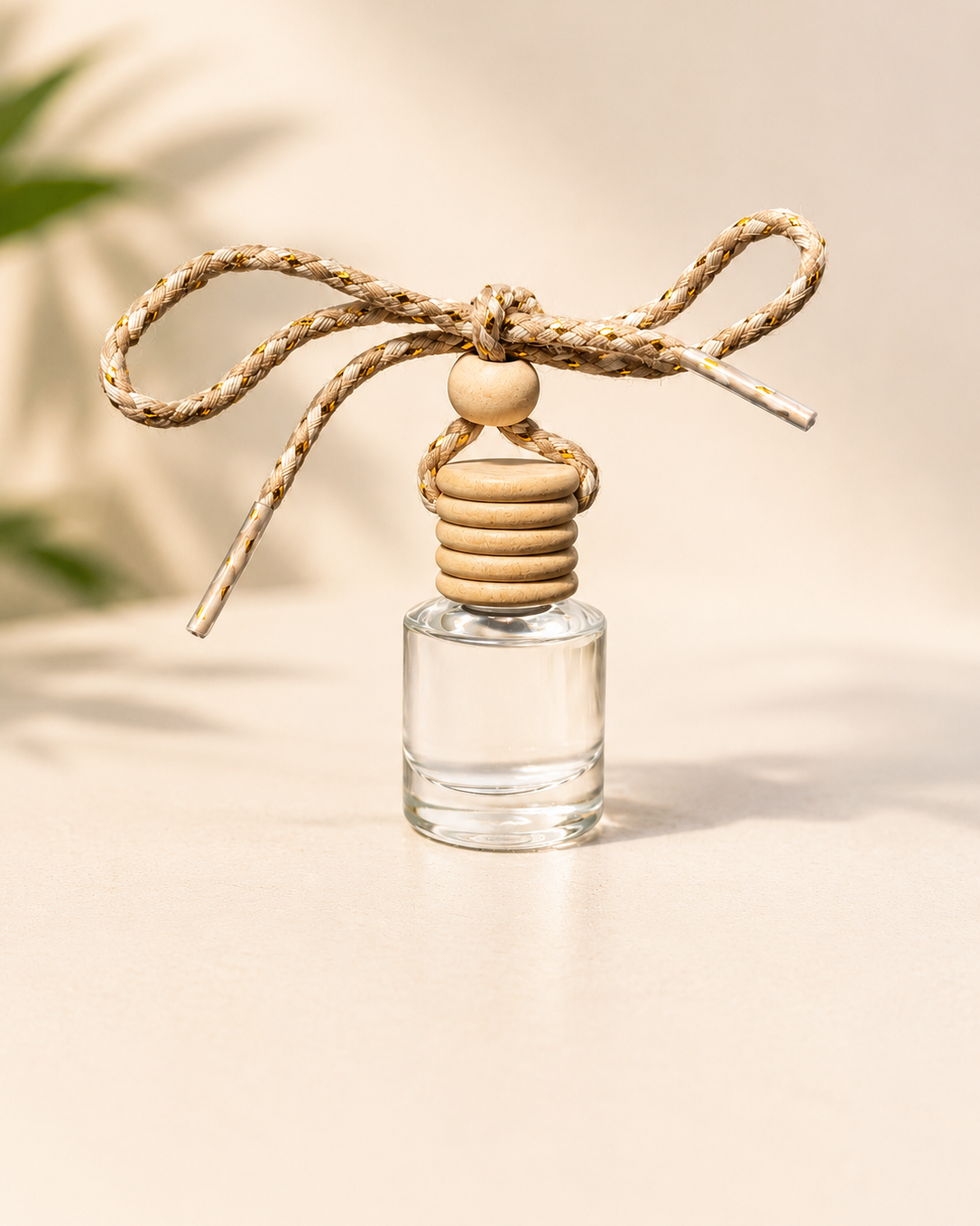 Clear glass diffuser with wooden beads and a string on a neutral background